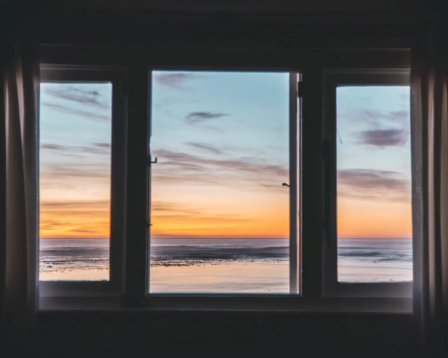 white wooden framed glass window near body of water