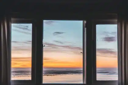 white wooden framed glass window near body of water