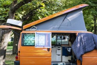 Van aménagé dans un camping, prêt pour l'aventure en plein air