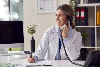 Médecin souriante en blouse blanche prête à aider les patients