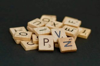 lettres en bois de scrabble en désordre sur une surface noire